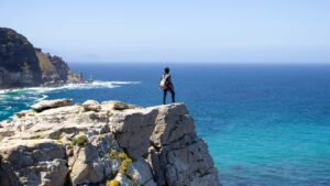 A person standing at the edge of a mountain at Cape Point
