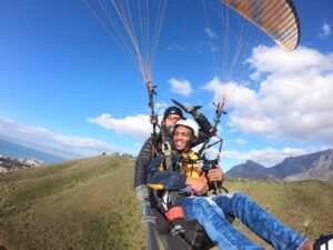 Modisha paragliding while Table Mountain appears in the background